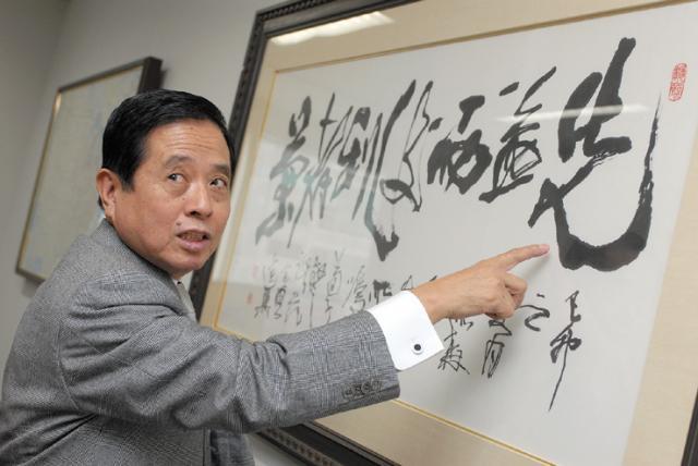 Kazuaki Mori standing next to a powerful message to his clients and colleagues. It reads, "If you value fairness over profit, you will succeed." 